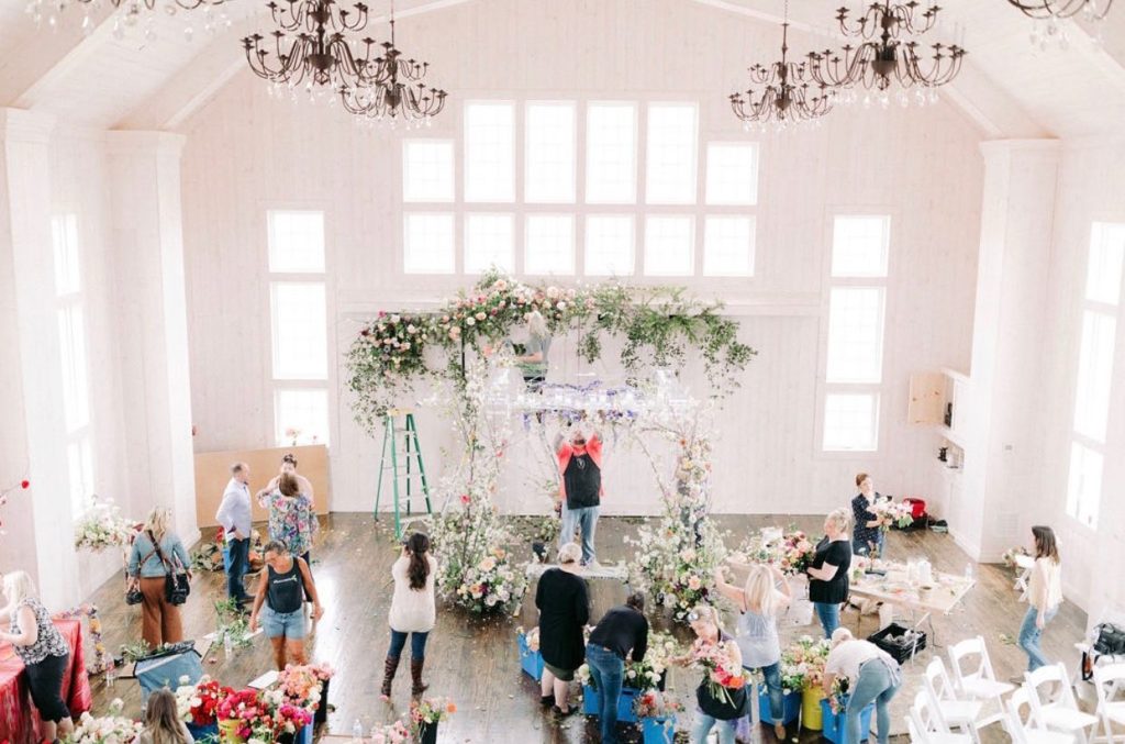 large wedding arch covered in greenery and blush flowers